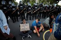 Protesters sit with their backs to riot policemen during nationwide unrest following the death in Minneapolis police custody of George Floyd, in Raleigh