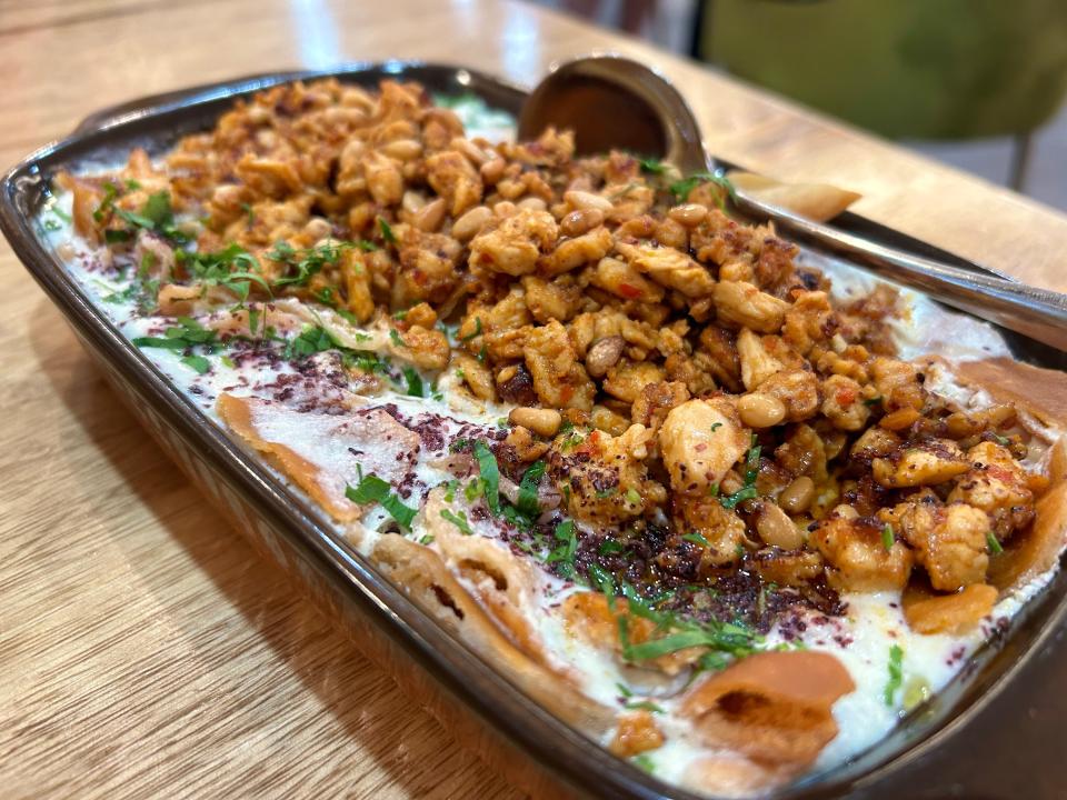 The chicken fatteh at Greenfield's Lebnani House is made of fried flatbread baked with creamy yogurt, spiced chicken pieces, pine nuts, sumac and parsley.