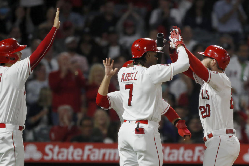 Los Angeles Angels' Jared Walsh, right, gets congratulations at the plate from Jo Adell (7) and Shohei Ohtani, left, after Walsh hits a three-run home run against the New York Yankees during the fourth inning of a baseball game in Anaheim, Calif., Tuesday, Aug. 31, 2021. (AP Photo/Alex Gallardo)