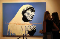 <p>Two visitors look at the artwork entitled ‘Mother Teresa’ by British Banksy is on display at the exhibition ‘The Art of Banksy’ in Berlin, Germany on June 20, 2017. (Felipe Trueba/EPA/REX/Shutterstock) </p>