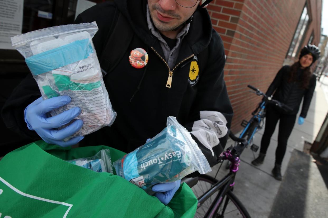 <span class="caption">Josh Ledesma displays safe injection supplies with outreach specialist Rachel Bolton outside the Access Drug User Health Program drop-in center in Cambridge, Massachusetts on March 31, 2020. </span> <span class="attribution"><a class="link " href="https://www.gettyimages.com/detail/news-photo/site-coordinator-josh-ledesma-displays-safe-injection-news-photo/1209081159?adppopup=true" rel="nofollow noopener" target="_blank" data-ylk="slk:Craig F. Walker/The Boston Globe via Getty Images;elm:context_link;itc:0;sec:content-canvas">Craig F. Walker/The Boston Globe via Getty Images</a></span>