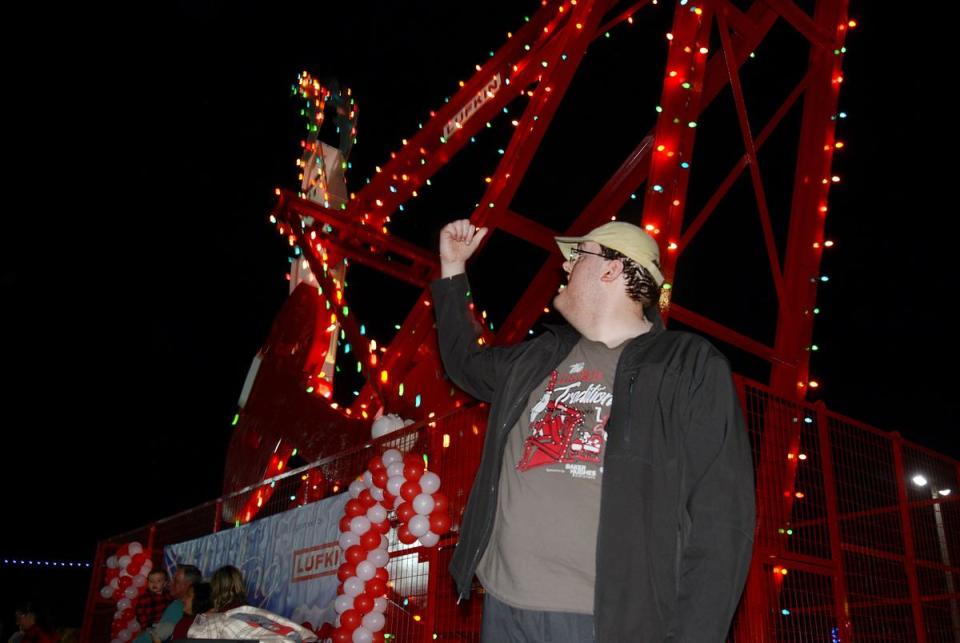 Justin Forrest, a very big fan, in front of Rudolph the Red Nosed Pumpjack during the lighting ceremony in downtown Lufkin.