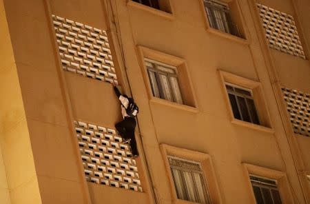 A "pichador", a graffiti artist who tags buildings and landmarks with angular, runic fonts, climbs up the facade of a nine-storey apartment building before tagging its wall with his personal signature, called "pichacao", in Sao Paulo, Brazil, April 19, 2017. REUTERS/Nacho Doce