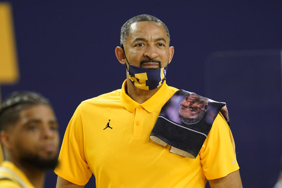 FILE - Michigan head coach Juwan Howard has a towel honoring former Georgetown head coach John Thompson on his shoulder in the second half of an NCAA college basketball game against Rutgers in Ann Arbor, Mich., in this Thursday, Feb. 18, 2021, file photo. Michigan coach Juwan Howard was honored as The Associated Press men's basketball coach of the year Thursday, April 1, 2021. (AP Photo/Paul Sancya, File)