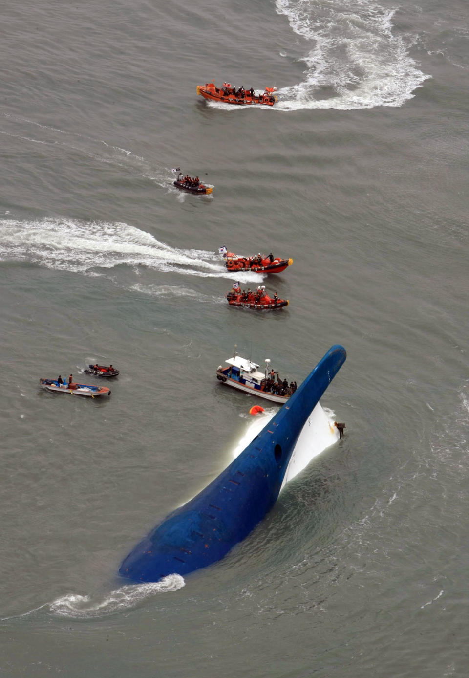 In this photo released by Jeollanamdo via Yonhap News Agency, South Korean rescue team boats and fishing boats try to rescue passengers of a ferry sinking off South Korea's southern coast, in the water off the southern coast near Jindo, south of Seoul, Wednesday, April 16, 2014. Nearly 300 people were still missing Wednesday several hours after a ferry carrying 477, most of them high school students, sank in cold waters off South Korea's southern coast. (AP Photo/Jeollanamdo via Yonhap) KOREA OUT