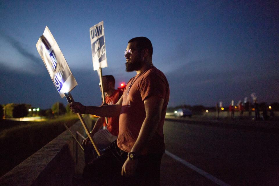 UAW members strike into the night on an overpass overlooking Highway 31 at the south entrance to the General Motors plant in Spring Hill on Friday, Sept. 20, 2019. 
