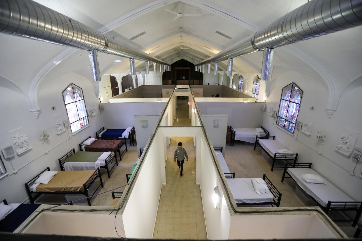 Resident specialist Rajaa Abbiss walks down the center hallway at the Detroit Rescue Mission Ministries' Mack warming center in Detroit on Nov. 12, 2021.