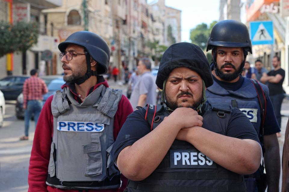 Palestinian journalists stand in shock following the destruction of Jala TowerAFP via Getty Images