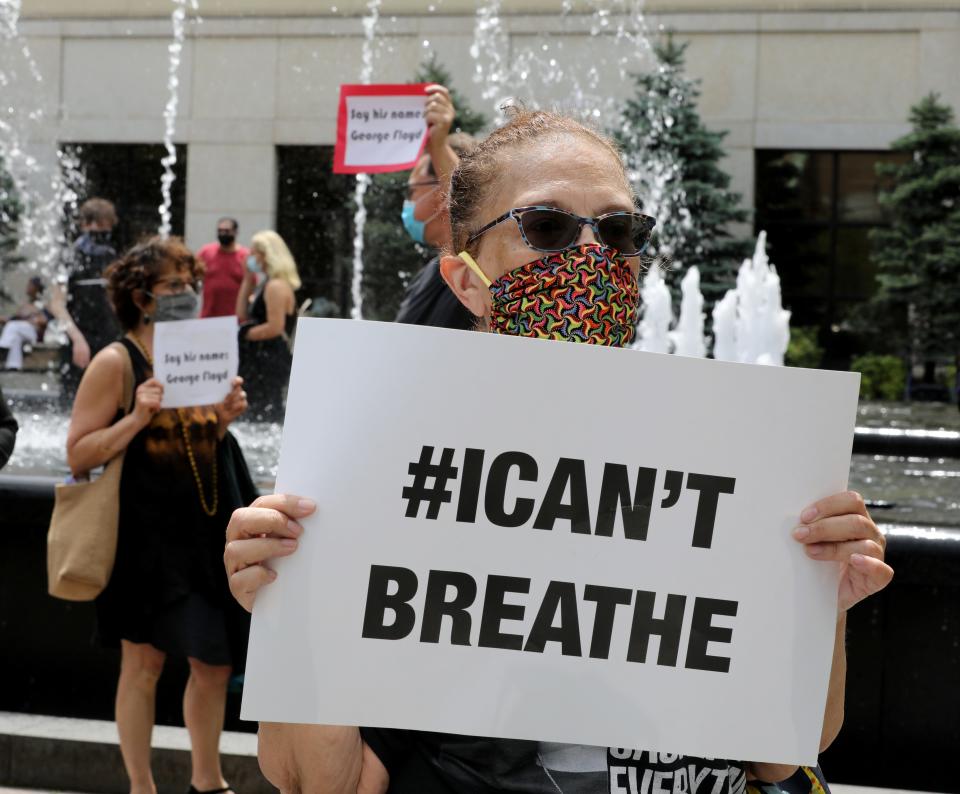 Susan Sheppard holds an "I can't breathe" sign during a vigil for George Floyd at the Renaissance Plaza in White Plains, New York, on Friday.