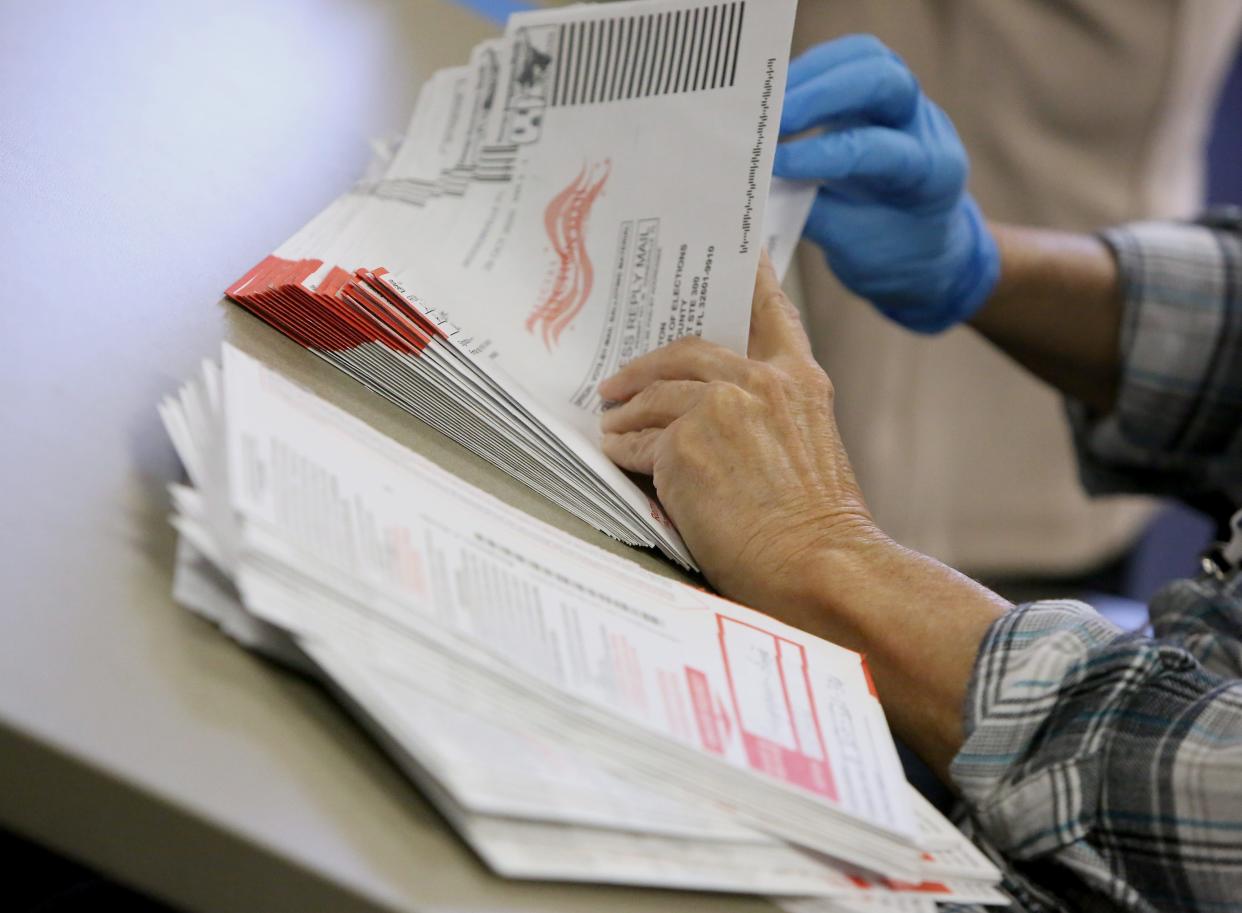 A canvasing board member organizes ballots before they are certified for the 2020 Election at the Alachua County Supervisor of Elections Office ahead of Election Day in Gainesville Fla., Nov. 2, 2020.