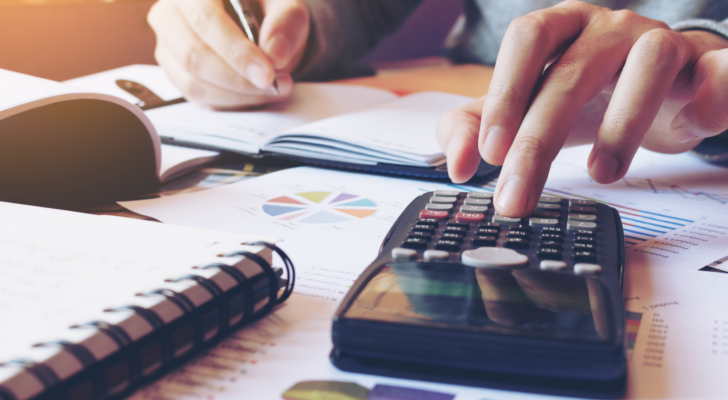 Man calculating finances on calculator. Finance. Finance stocks.