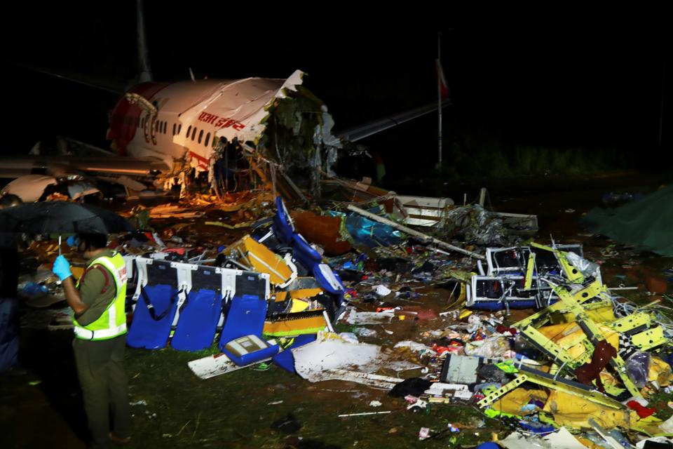 A security personnel stands guard in front of the wreckage from an Air India Express jet, which was carrying more than 190 passengers and crew from Dubai, after it crashed at Calicut International Airport in Karipur, Kerala, early on August 8, 2020. - At least 17 people were killed on August 7 when a passenger jet was ripped in two after it overshot and skidded off the runway upon landing in southern India, officials said. (Photo by Arunchandra BOSE / AFP) (Photo by ARUNCHANDRA BOSE/AFP via Getty Images)