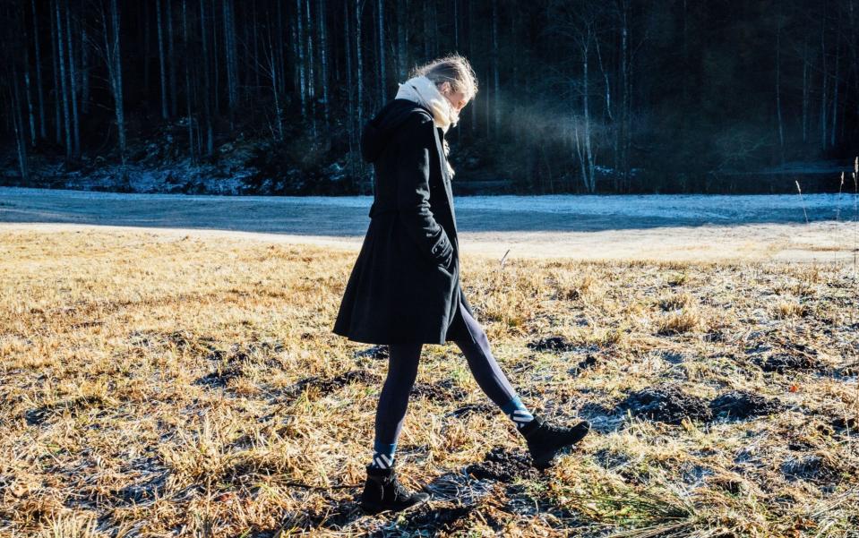 Girl walks on frosty ground in wintertime