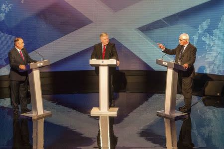 Alex Salmond (L), leader of the pro-independence Scottish National Party, and Alistair Darling, head of the "Better Together" anti-independence campaign, take part in a television debate with host Bernard Ponsonby (C) in Glasgow August 5, 2014. REUTERS/Peter Devlin/STV/Handout via Reuters