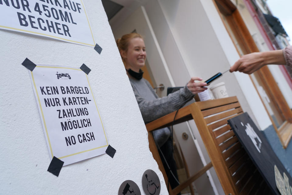 BERLIN, GERMANY - APRIL 29: A sign notifies customers of no cash payments as a customer pays with a credit card at Jones ice cream shop in Schoeneberg district during the novel coronavirus crisis on April 29, 2020 in Berlin, Germany. Many retailers are switching to non-cash payment options as a means to protect staff from infection with the virus. (Photo by Sean Gallup/Getty Images)