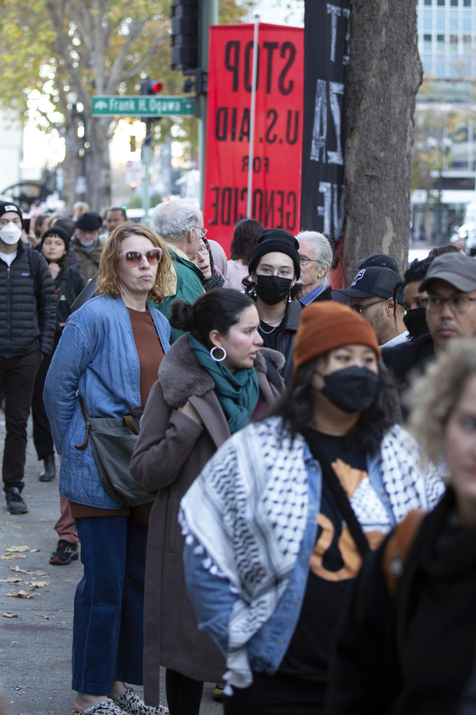 People wait outside City Hall to attend a special council session to consider a resolution calling for an immediate ceasefire in Gaza, Monday, Nov. 27, 2023, in Oakland, Calif. (AP Photo/D. Ross Cameron)