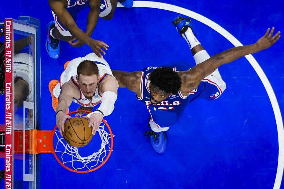 New York Knicks' Donte DiVincenzo, left, dunks past Philadelphia 76ers' Joel Embiid, right, during the second half of Game 6 in an NBA basketball first-round playoff series, Thursday, May 2, 2024, in Philadelphia. (AP Photo/Matt Slocum)