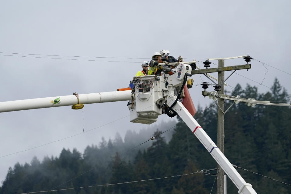 PG&E workers service a power line after an earthquake in Rio Dell, Calif., Wednesday, Dec. 21, 2022. (AP Photo/Godofredo A. Vásquez)