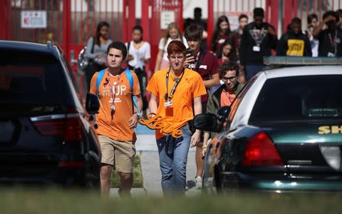 Ryan Deitsch, a senior, carries a sign that reads, 'love,' as he joins his fellow students from Marjory Stoneman Douglas High School - Credit: Getty Images