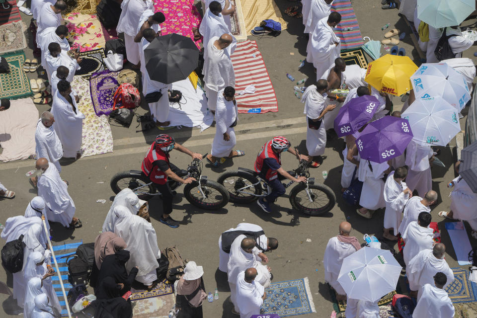 Saudi Red Crescent medical team members cycle through pilgrims outside Namira Mosque in Arafat on the second day of the annual Hajj pilgrimage near the holy city of Mecca, Saudi Arabia, Tuesday, June 27, 2023. Around two million pilgrims are converging on Saudi Arabia's holy city of Mecca for the largest Hajj since the coronavirus pandemic severely curtailed access to one of Islam's five pillars. (AP Photo/Amr Nabil)