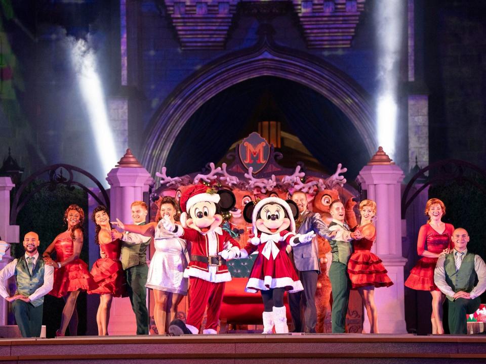 mickey minnie and dancers performing on stage at the magic kingdom Christmas party event