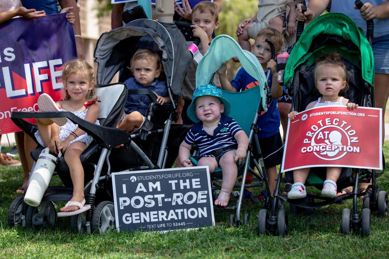 Children were given signs with anti-abortion slogans as part of a small gathering of anti-abortion activists following the recent Supreme Court decision in Dobbs v. Jackson's Women Health Organization outside the Arizona State Capitol in Phoenix on June 25, 2022. The court's decision overturns the 50-year-old Roe v. Wade ruling that established the legal right to abortion in the United States.