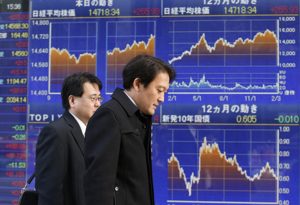 Men walk past an electronic stock indicator showing charts of Japan's benchmark Nikkei 225 which gained 255.93 points, or 1.77 percent, and closed at 14,718.34 in Tokyo Monday, Feb. 10, 2014. Asian stock markets were mostly higher Monday as investors looked ahead to Janet Yellen's first comments before Congress as the new Federal Reserve chairwoman. (AP Photo/Shizuo Kambayashi)