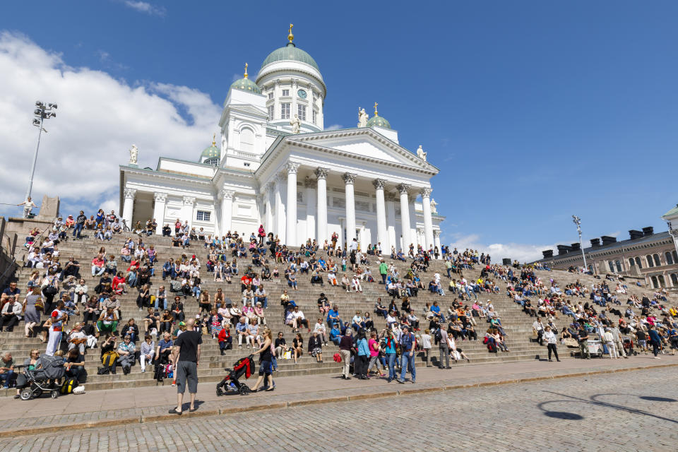 Las personas más felices del mundo tienen un problema de deuda. Los ciudadanos disfrutan de un día soleado en la escalinata de la Catedral de Helsinki, Finlandia. Foto: Getty Images. 