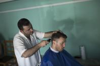 Nick, en la fotografía en una barbería de Ballsh, vive en Londres, donde trabaja para una empresa de construcción. Había regresado a Albania para pasar un tiempo con su familia y espera volver a Reino Unido después del verano si las restricciones por el coronavirus se lo permiten. (Foto: Daniel Cole / AP).