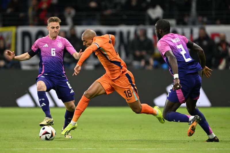 The Netherlands' Donyell Malen (C) and Germany's Joshua Kimmich (L) and Germany's Antonio Ruediger battle for the ball during the International Friendly soccer match between Germany and Netherlands at the Deutsche Bank Park stadium. Federico Gambarini/dpa