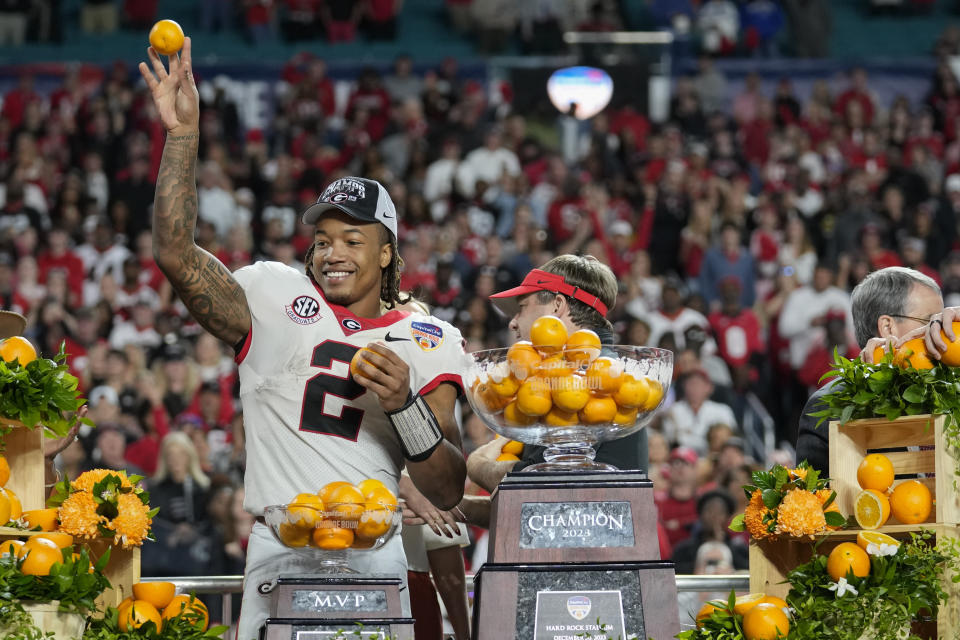 Georgia running back Kendall Milton throws oranges from his MVP trophy after Georgia defeated Florida State in the Orange Bowl NCAA college football game, Saturday, Dec. 30, 2023, in Miami Gardens, Fla. (AP Photo/Rebecca Blackwell)