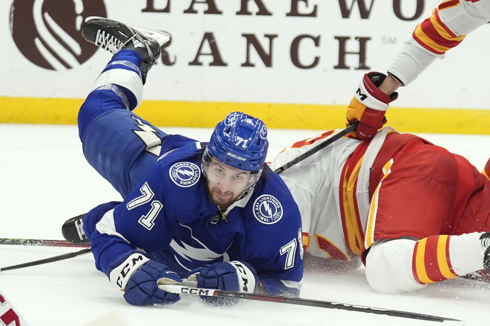 Tampa Bay Lightning center Anthony Cirelli (71) gets tripped by Calgary Flames center Nazem Kadri (91) during the second period of an NHL hockey game Thursday, March 7, 2024, in Tampa, Fla. (AP Photo/Chris O'Meara)