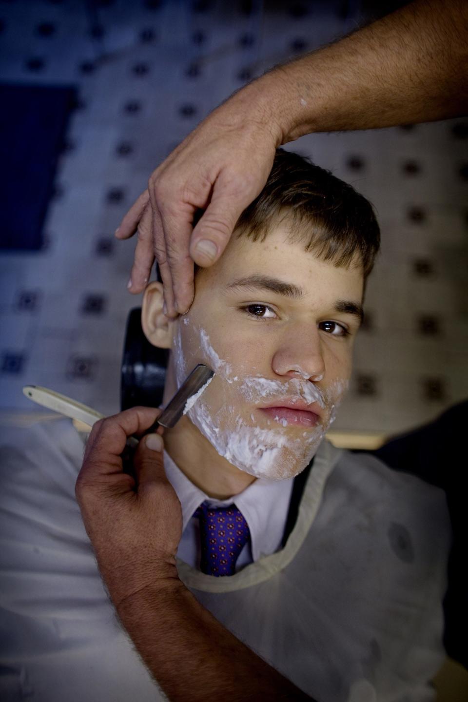 Magnus Carlsen, 19, looks on while being shaved at a barbers shop in Oslo on August 31, 2009.