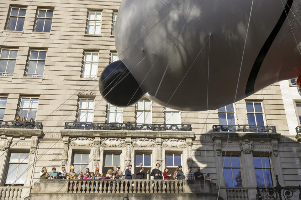 Spectators watch from a balcony as the Beagle Scout Snoopy balloon floats by along Central Park West during the Macy's Thanksgiving Day parade, Thursday, Nov. 23, 2023, in New York. (AP Photo/Jeenah Moon)