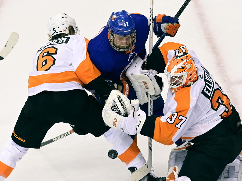 New York Islanders center Leo Komarov (47) and Philadelphia Flyers defenseman Travis Sanheim (6) battle for position in front of Flyers goaltender Brian Elliott (37) during the second period of an NHL Stanley Cup Eastern Conference playoff hockey game, Sunday, Aug. 30, 2020 in Toronto. (Frank Gunn/The Canadian Press via AP)