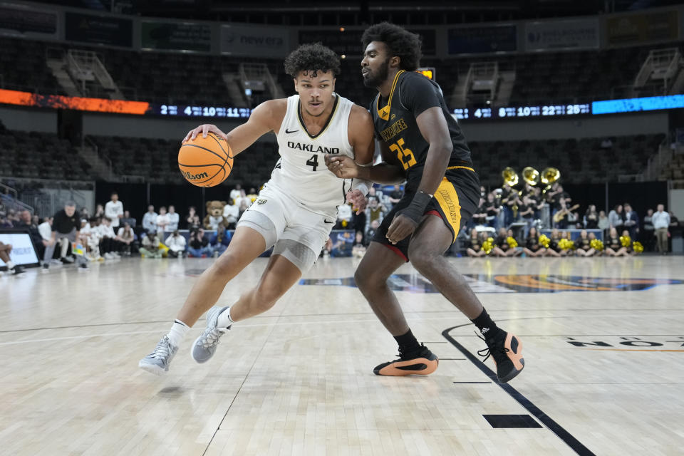 Oakland forward Trey Townsend (4) drives around Milwaukee guard Aaron Franklin (25) during the first half of an NCAA college basketball game for the championship of the Horizon League men's tournament in Indianapolis, Tuesday, March 12, 2024. (AP Photo/AJ Mast)