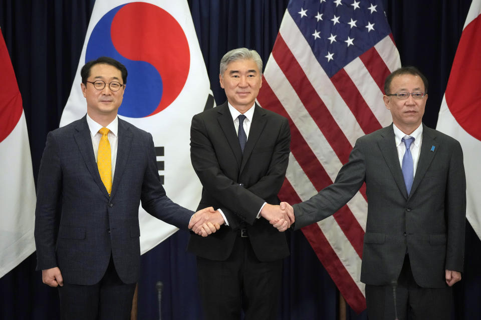 U.S. Special Representative for North Korea who is also U.S. Ambassador to Indonesia Sung Y. Kim, center, holds hands with South Korean Special Representative for Korean Peninsula Peace and Security Affairs Kim Gunn, left, and Japanese Ministry of Foreign Affairs Director General for Asian and Oceanian Affairs Bureau Takehiro Funakoshi at the start of their trilateral meeting on North Korea at the U.S. Embassy in Jakarta, Indonesia, Tuesday, Dec. 13, 2022. (AP Photo/Dita Alangkara)