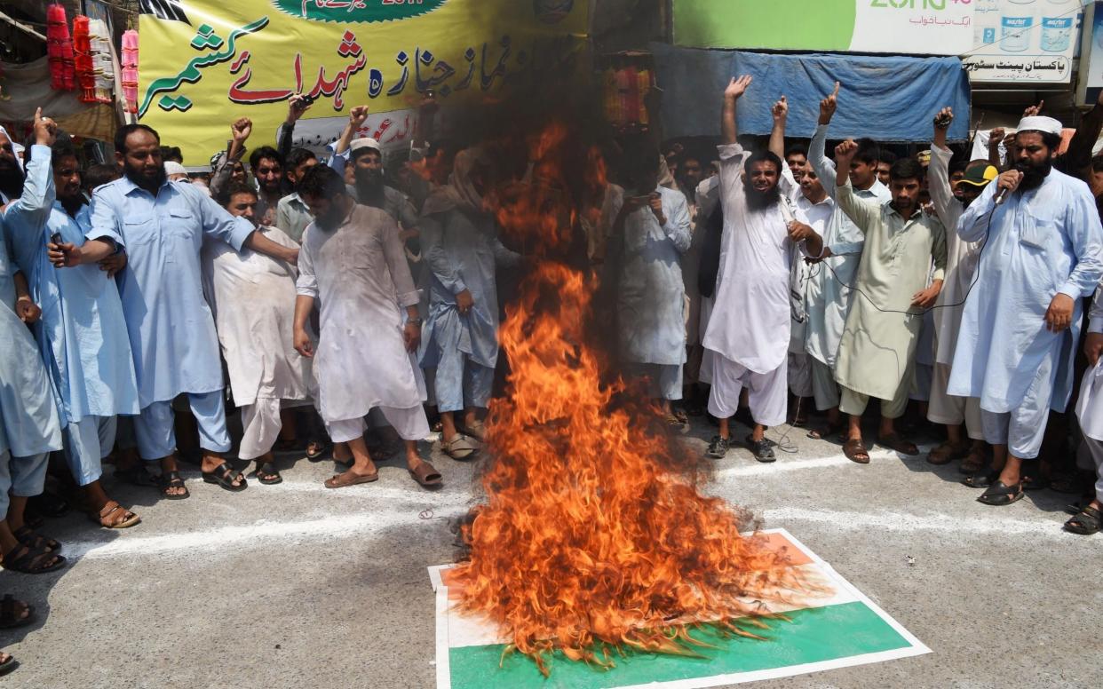 Pakistani supporters of the hardliner Islamic group of Jamaat-ud-Dawa (JuD) shout solgans next to a burning Indian flag   - AFP