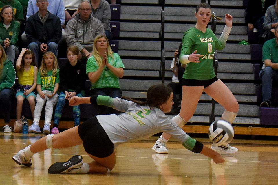 Newark Catholic junior libero Ava Heffley gets a dig as teammate senior Maddie Kauble looks on during a Division IV regional semifinal on Thursday, Nov. 3, 2022 at Pickerington High School North. The Green Wave defeated the Tomcats in three straight sets.
