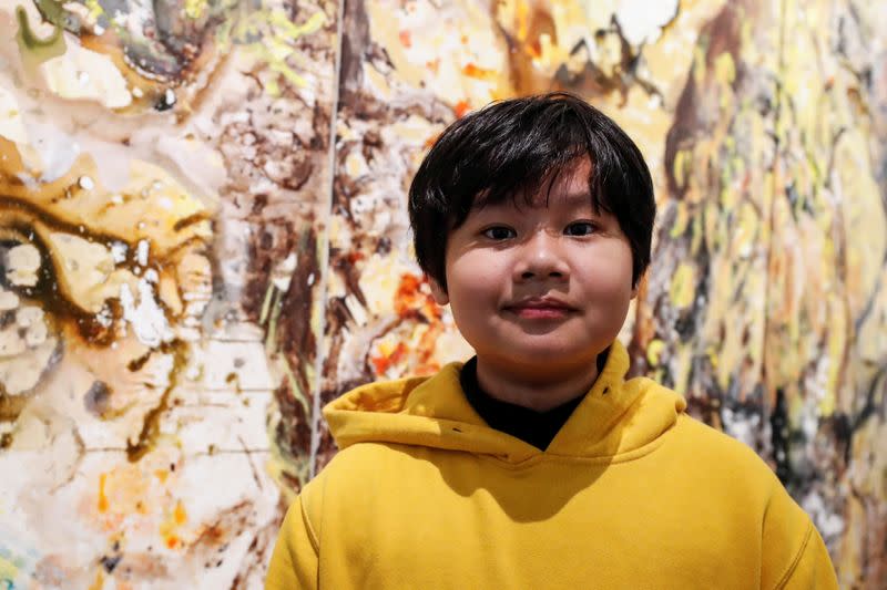 Xeo Chu, a Vietnamese art prodigy, poses in front of one of his pieces before his debut solo exhibition at the Georges Berges Gallery in New York