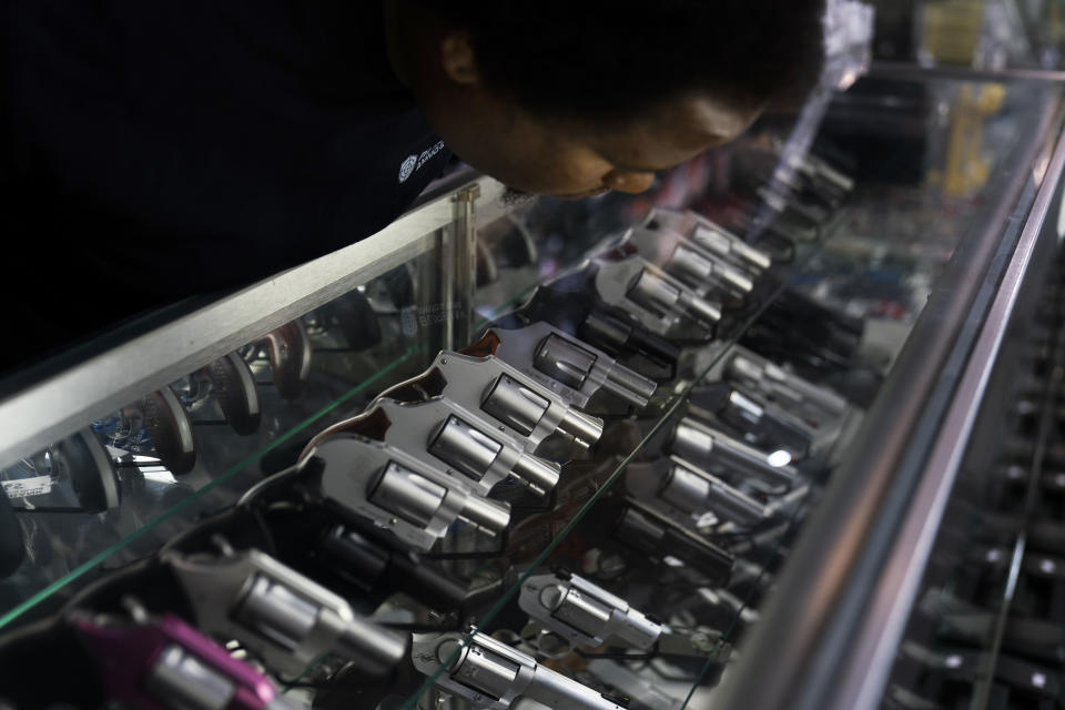 FILE - A sales associate arranges guns on display at Burbank Ammo & Guns in Burbank, Calif., June 23, 2022. On Friday, Feb. 3, 2023, a federal judge in Oklahoma ruled that a federal law prohibiting people who use marijuana from owning firearms is unconstitutional, the latest challenge to firearms regulations after the U.S. Supreme Court’s conservative majority set new standards for reviewing the nation’s gun laws. (AP Photo/Jae C. Hong, File)