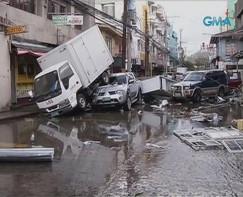 Piled up vehicles are pictured on a flooded street filled with debris after Typhoon Haiyan hit the central Philippine city of Tacloban