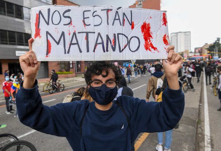 Un manifestante sostiene un cartel que dice 'Nos están matando' durante una protesta contra una reforma tributaria propuesta por el gobierno del presidente colombiano Iván Duque en Bogotá, el 4 de mayo de 2021