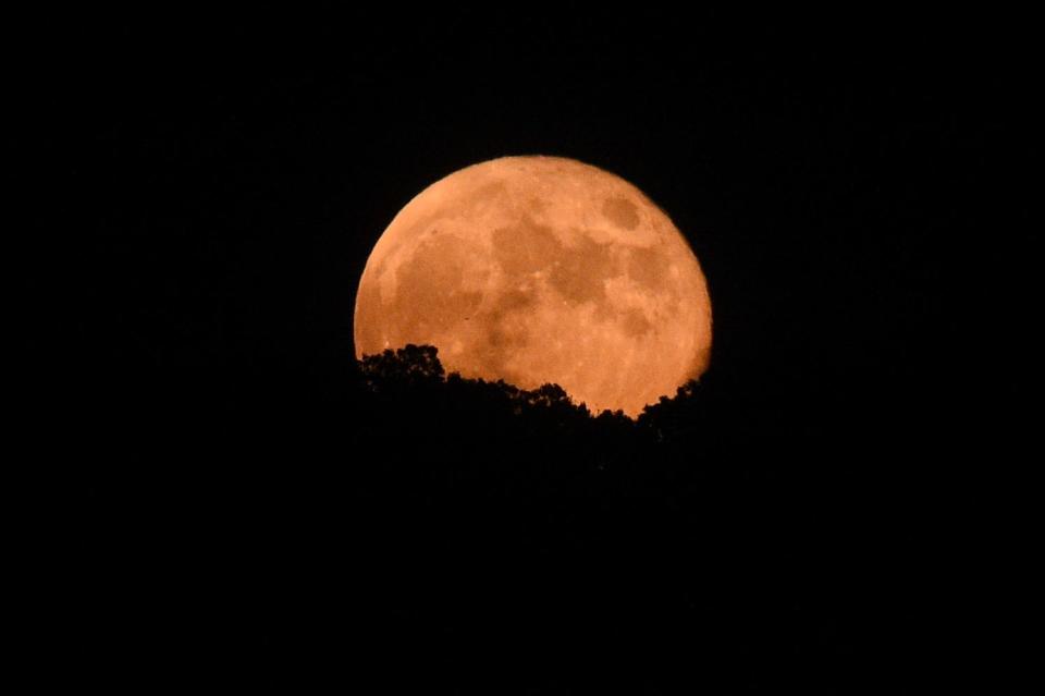 The last supermoon of 2023 rises over the horizon at a high school football game between Farragut and Bradley Central at Farragut, Friday, Sept. 29, 2023 in Knoxville, Tennessee.