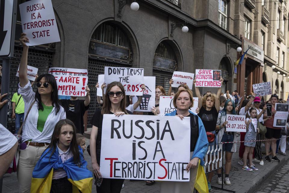 FILE - Relatives of soldiers from the Azov Regiment and protesters hold banners against Russia in Lviv, Ukraine, on Aug. 18, 2022. The widespread resolve against Russia's invasion of Ukraine demonstrates the power of a unified response against human rights abuses, a leading watchdog group said Thursday, Jan. 12, 2023, and comes amid growing dissatisfaction with autocratic regimes, with protests in Iran, China and elsewhere. (AP Photo/Evgeniy Maloletka, File)