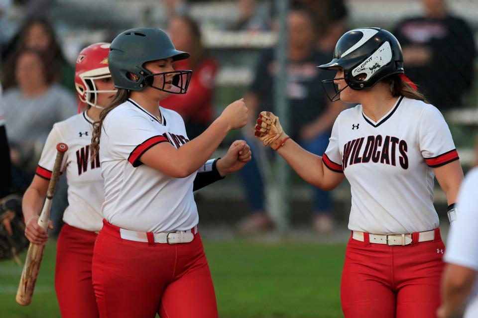 Baker County's Haley Marker (14) fist-bumps teammate Mallory Jackson (25) after a sacrifice RBI to take the lead in an April game.