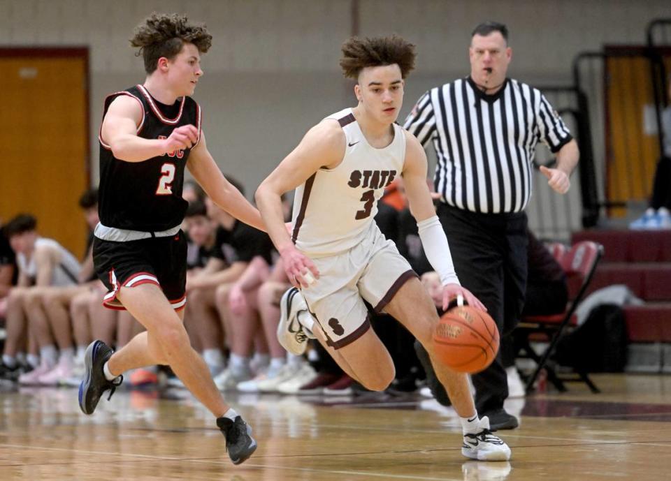 State College’s Braeden Shrewsberry dribbles down the court ahead of an Upper St. Clair defender during the PIAA first round game on Saturday, March 11, 2023. State College won, 72-42.