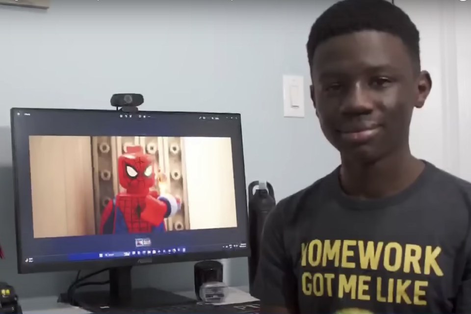 the teen posing with his project on the computer