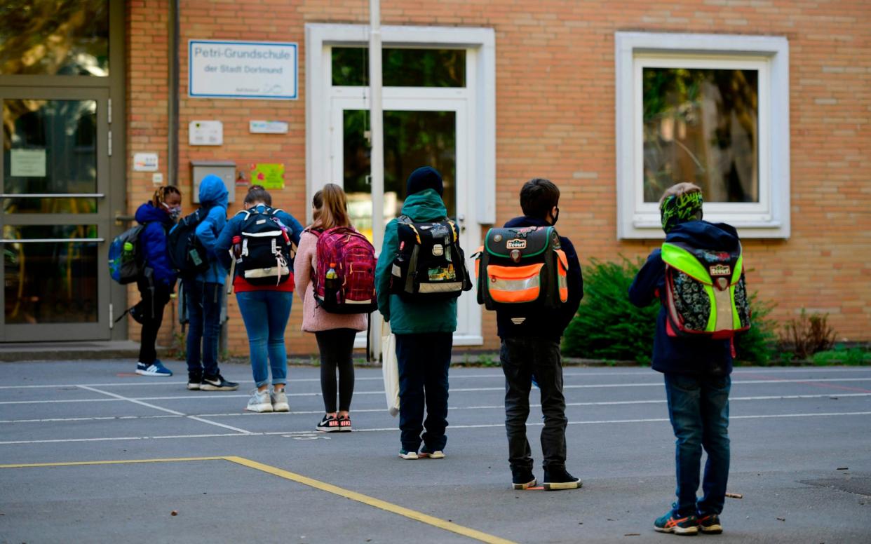 Children respect social distancing rules as they line up to enter the Petri primary school in Dortmund, western Germany, on May 7, 2020, as the school reopens for some pupils following lockdown due to the new coronavirus Covid-19 pandemic. - The primary schools in the western federal state of North Rhine-Westphalia reopened as planned for fourth-graders. (Photo by Ina FASSBENDER / AFP) (Photo by INA FASSBENDER/AFP via Getty Images) - INA FASSBENDER/AFP