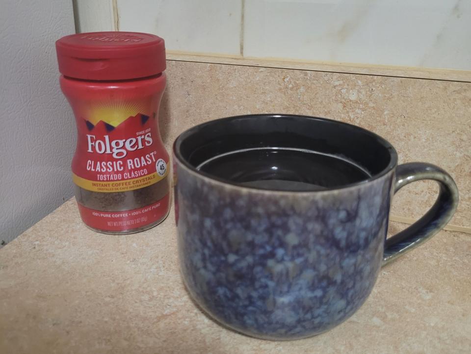 folgers instant coffee next to a prepared cup of coffee